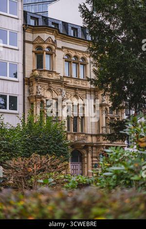 Un bâtiment historique orné à Düsseldorf se dresse entre des structures modernes, présentant des détails architecturaux complexes Banque D'Images