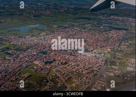 Vue aérienne d'Assemini, près de Cagliari, Sardaigne, montrant le paysage urbain, les champs verts, et la structure de la ville de la fenêtre de l'avion Banque D'Images