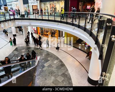 Manchester, Royaume-Uni - 26 septembre 2025 : scène animée du centre commercial Arndale avec des gens sur l'escalier roulant et des acheteurs errant dans les magasins. Banque D'Images