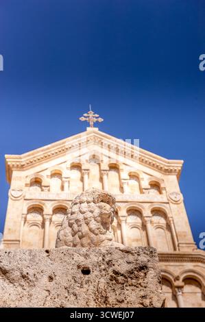 Façade de la cathédrale de Cagliari en Sardaigne, Italie, avec sculpture de lion en pierre au premier plan sous un ciel bleu profond Banque D'Images