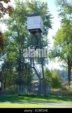 Vieille tour de belvédère en bois debout au-dessus de Green Park Trees avec White Cabin. Le cadre en métal haut supporte une cabine de guet en bois blanc au-dessus d'un lea Banque D'Images