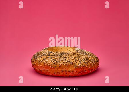 Plan studio de pain bretzel avec du gros sel sur fond rose représentant le concept de casse-croûte croquante de processus de cuisson traditionnel et la nourriture artisanale Banque D'Images