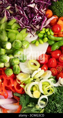 Variété de légumes frais hachés : carottes, concombre, poivron rouge, tomate, salade, oignon sur un fond clair. Vue de dessus. Banque D'Images