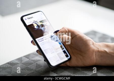 Nouvelles au téléphone. Communiqué de presse dans les médias. Article ou titres. Lecture du journal en ligne dans l'écran du téléphone portable. Dernier site Web mobile de maquette numérique. Banque D'Images