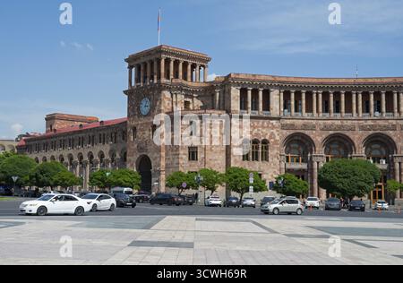 Bâtiment historique avec tour de l'horloge et des arches, voitures passant sur une place, Palais du Gouvernement sur la place de la République, Erevan, Erevan, Arménie Banque D'Images