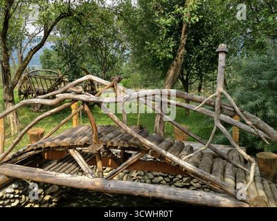 Pont en bois à travers le ruisseau et charrette à cheval en bois dans une montagne de Transylvanie, Roumanie Banque D'Images