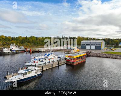 Vladimirovka, Russie - 13 mai 2024 : vue surélevée de divers navires et d'une station-service flottante amarrée à un quai, à côté de bâtiments industriels modernes Banque D'Images