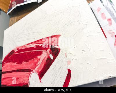 Gros plan d'une toile montrant une peinture acrylique inachevée de mini voiture rouge avec des coups de pinceau visibles et des détails texturaux. préparation du calque sous-jacent d'esquisse Banque D'Images