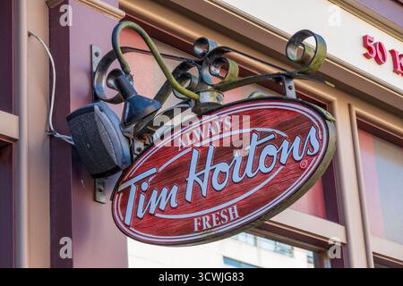 Saint John, NB - CA - 30 septembre 2025 gros plan d'une enseigne Tim Hortons ovale rouge et blanche accrochée à l'extérieur d'un bâtiment portant le numéro 501 ab Banque D'Images