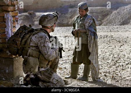 GHARTALLAH, AFGHANISTAN - 24 décembre 2010 - le Cpl Patrick Kelley du corps des Marines des États-Unis parle avec un garçon afghan tout en assurant la sécurité lors de l'inspection d'une nouvelle école en construction à Ghartallah, dans le district de Musa Qaleh, en Afghanistan. Kelley, un sous-officier des affaires civiles, est affecté au 1er bataillon du 8e Marines - photo : Geopix/USMC/Joshua J Hines Banque D'Images