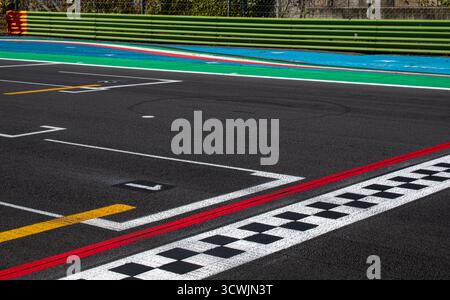 Ligne d'arrivée à damier sur piste d'asphalte et panneau de position de poteau, course de sport automobile Banque D'Images