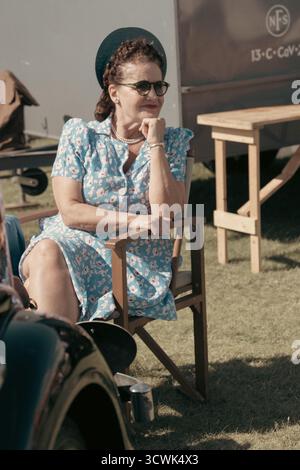 Femme dans les années 1940 robe et chapeau assis à l'événement extérieur de reconstitution de temps de guerre Banque D'Images