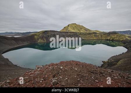 Lac de cratère Hnausapollur (Bláhylur), à Nyrðri Fjallabak avec des eaux bleues et des pentes de scories rouges près de Landmannalaugar, dans les hauts plateaux islandais Banque D'Images