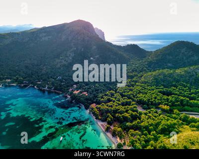 Vue aérienne des eaux turquoise rencontre les forêts verdoyantes de Cala Ratjada, créant un contraste saisissant avec la côte accidentée, Cala Ratjada, Banque D'Images