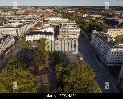 Vue aérienne de Gustav Adolfs torg baigné de lumière douce, encadré par des arbres matures projetant des ombres sur la place pavée, Malmo, Suède. Banque D'Images