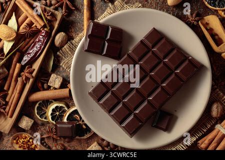 Chocolat noir et diverses épices et assaisonnements pour faire des boissons aromatiques. Vue de dessus. Banque D'Images