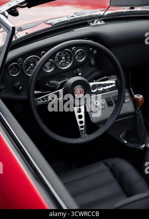 Volant et tableau de bord de roadster MG rouge. intérieur en cuir noir de la voiture de sport classique des années 1960. Banque D'Images