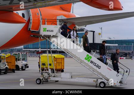 Passagers débarquant d'un avion EasyJet via les escaliers d'embarquement WISAG à l'aéroport de Munich avec des véhicules de service à proximité.Munich, Allemagne Banque D'Images
