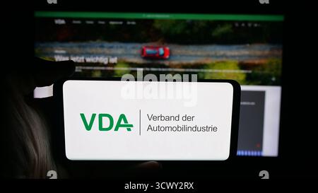 Stuttgart, Allemagne - 10-06-2025 : personne tenant un téléphone portable avec le logo de German Verband der Automobilindustrie (VDA) sur l'écran devant la page web. Banque D'Images