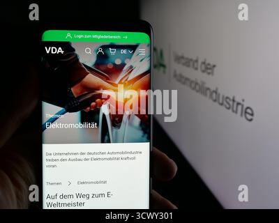 Stuttgart, Allemagne - 10-06-2025 : personne tenant un téléphone portable avec la page web de German Verband der Automobilindustrie (VDA) sur l'écran devant le logo. Banque D'Images