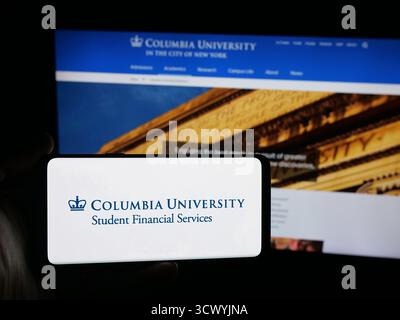 Stuttgart, Allemagne - 10-09-2025 : personne tenant un smartphone avec le logo de l'Université Columbia dans la ville de New York sur l'écran devant le site Web. Banque D'Images