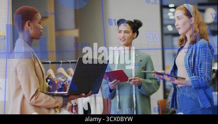 Discuter de trois professionnels examinant des graphiques de données en studio, avec un ruban à mesurer pour ordinateur portable Banque D'Images