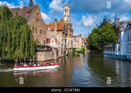 Bateaux de tourisme sur le canal de Dijver depuis Rosary Quay, avec le Befort au loin, dans le centre historique de Bruges en Flandre occidentale, Belgique, Europe Banque D'Images