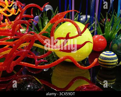 SEATTLE - APR 25, 2025 - les tentacules de verre rouge, orange et jaune poussent et s'enroulent autour d'une grande sphère de verre jaune ronde, entourée d'autres Banque D'Images