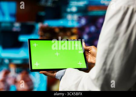 Le spécialiste de la santé utilise une application pour tablette à écran isolé, examinant les tomodensitomètres et les analyses de données IRM. Scientifique dans un laboratoire de recherche médicale visualisant des données de santé sur des panneaux futuristes à l'aide d'un dispositif chroma Key Banque D'Images