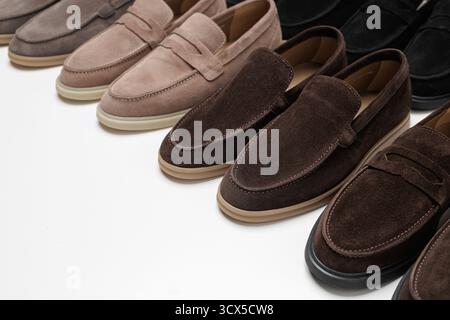 Rangée de mocassins en daim pour hommes dans des couleurs assorties sur un fond de studio propre, idéal pour la vente au détail de mode, les mises en page de catalogue et les bannières de magasin en ligne. Banque D'Images