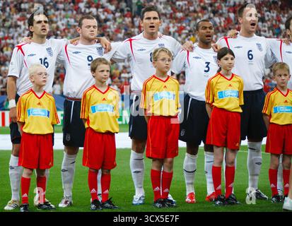 Les joueurs anglais Owen Hargreaves (16 ans), Wayne Rooney (9 ans), Frank Lampard (8 ans), Ashley Cole (3 ans) et John Terry (6 ans) chantent l'hymne national avant un match de quart de finale de la Coupe du monde contre le Portugal le 1er juillet 2006 à Gelsenkirchen, en Allemagne. Usage éditorial exclusif. Utilisation commerciale interdite. Banque D'Images