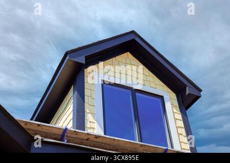La maison nouvellement construite présente une architecture moderne avec de grandes fenêtres conception de toit unique contre Banque D'Images