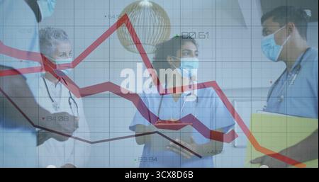 Discussion des tendances sur la superposition de graphiques linéaires dans le couloir de l'hôpital avec les stéthoscopes de tablette à presse-papiers Banque D'Images