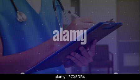 Écriture médecin masculin dans le stéthoscope bleu gommage prenant des notes dans le couloir de la clinique, avec presse-papiers, stylo Banque D'Images