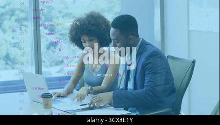 Collaboration des collègues en costume examinant des documents à la table de conférence avec un ordinateur portable et un stylo Banque D'Images