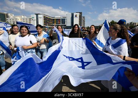 Petah Tikva, Israël. 13 octobre 2025. Des gens arrivent à l’hôpital Beilinson pour accueillir cinq des vingt otages libérés de la captivité du Hamas dans le cadre de l’accord visant à mettre fin à la guerre. Le peuple israélien a célébré la libération des otages après deux ans de captivité du Hamas et la fin de la guerre. Des foules de personnes sont arrivées aux hôpitaux pour saluer le retour des derniers otages qui étaient restés en captivité par le Hamas. Le public dansait et se réjouissait grandement. (Photo de Yael Guisky Abas/SOPA images/SIPA USA) crédit : SIPA USA/Alamy Live News Banque D'Images