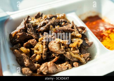 Gros plan d'un plat traditionnel namibien de viande grillée servi dans un récipient à emporter à Usakos, Namibie. L'image montre des morceaux tendres et juteux de cuisinés Banque D'Images