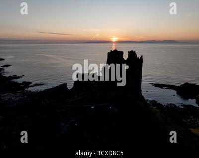 Vue aérienne au coucher du soleil du château de Dunure dans le South Ayrshire, en Écosse, montrant la forteresse côtière en ruine en silhouette contre un ciel nocturne spectaculaire. Banque D'Images
