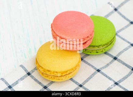 gâteaux aux macarons multicolores sur une serviette à carreaux. macarons rouges, verts, jaunes Banque D'Images