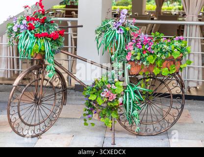 Décoration en métal à l'avant du café d'été, faite en forme de vélo et décorée de fleurs Banque D'Images