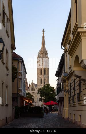L'église blanche néo-gothique Matthias dans le quartier du château de Buda à Budapest, vue entre les bâtiments Banque D'Images