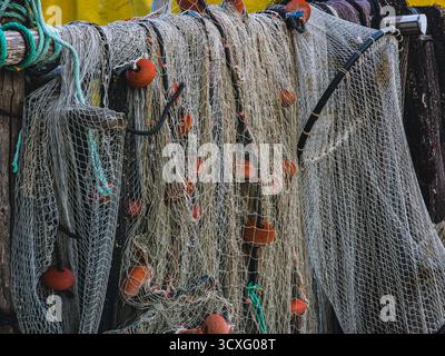 Filets de pêche traditionnels enchevêtrés avec flotteurs orange suspendus sur un cadre en bois, détail du village méditerranéen, septembre 2025 Banque D'Images