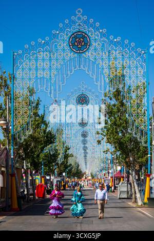 Fuengirola, Málaga, Espagne. 12 octobre 2025. Jeunes femmes en robes de flamenco traditionnelles marchant à travers le parc des expositions de Fuengirola Banque D'Images
