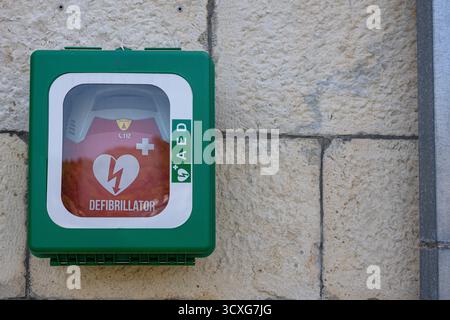STOMORSKA, CROATIE, 08.27.2025 :Une armoire murale vert vif abrite un défibrillateur rouge, clairement étiqueté et protégé. Idéal pour la sécurité publique Banque D'Images