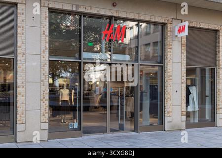 Vue extérieure d'un magasin H&M à Utrecht, pays-Bas, avec le logo rouge proéminent et des mannequins visibles à travers la grande vitrine. Banque D'Images