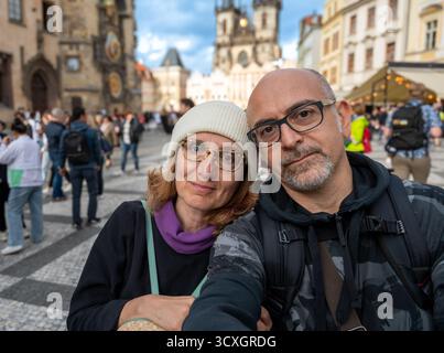 Prague, République tchèque, 7 août 2023. Un couple d'âge mûr prend un selfie sur la place emblématique et bondée de la vieille ville. Arrière-plan flou, destin de voyage Banque D'Images