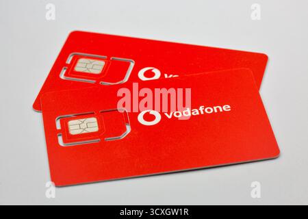 Kiev, Ukraine - 07 décembre 2024 : deux cartes SIM Vodafone rouges avec puce et logo en gros plan. Cartes prépayées d'opérateur de réseau mobile montrant standard et M. Banque D'Images