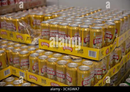 Porec, Croatie - 31 mai 2025 : plusieurs plateaux de canettes de bière Ozujsko empilés dans l'entrepôt ou le magasin Lidl, avec l'emballage jaune reconnaissable et le son Banque D'Images