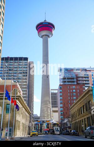 La Calgary Tower se dresse sur un ciel bleu clair, entourée de bâtiments en verre et en briques au cœur du quartier du centre-ville Banque D'Images