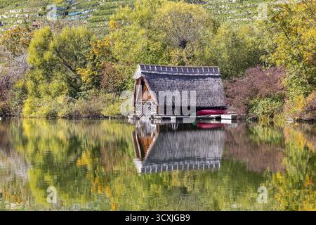 Hangar à bateaux sur le lac Max-Eyth en automne avec un feuillage coloré. Stuttgart, Bade-Wuerttemberg, Allemagne Banque D'Images